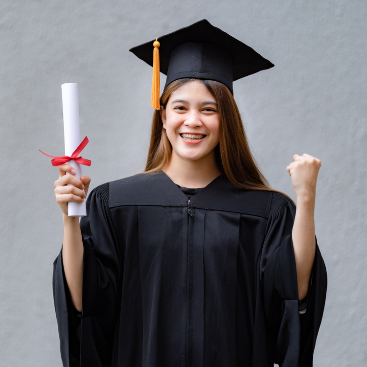 A Young Happy Asian Woman University Graduate in Graduation Gown